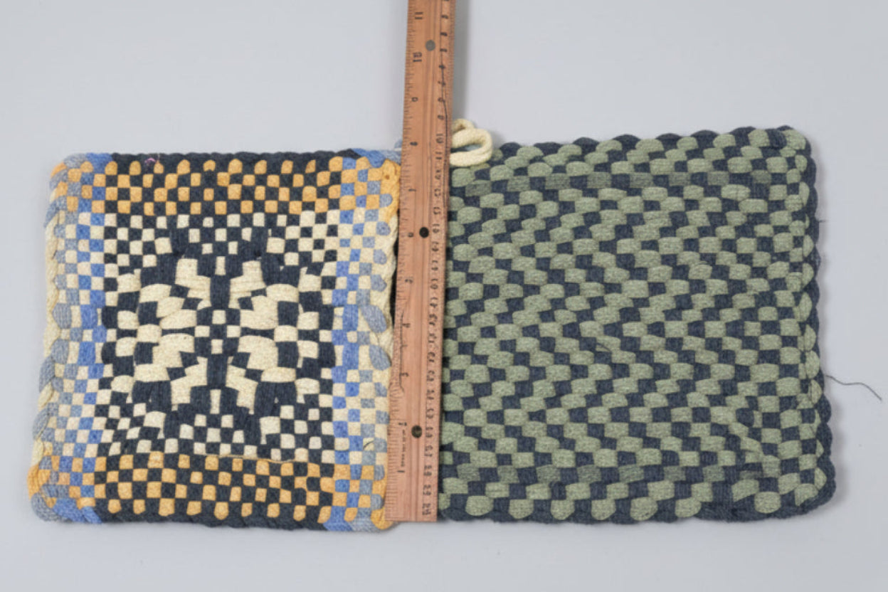 Textile with a checkered pattern and a ruler for scale, on a pink fabric background.