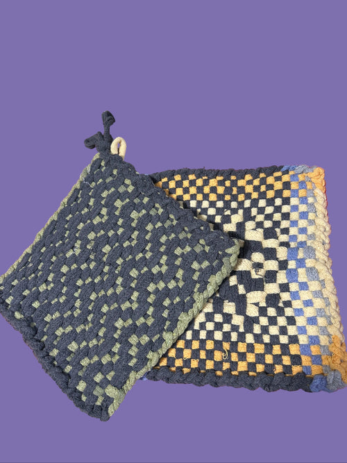 Two woven coasters on a pink surface with a blurred background