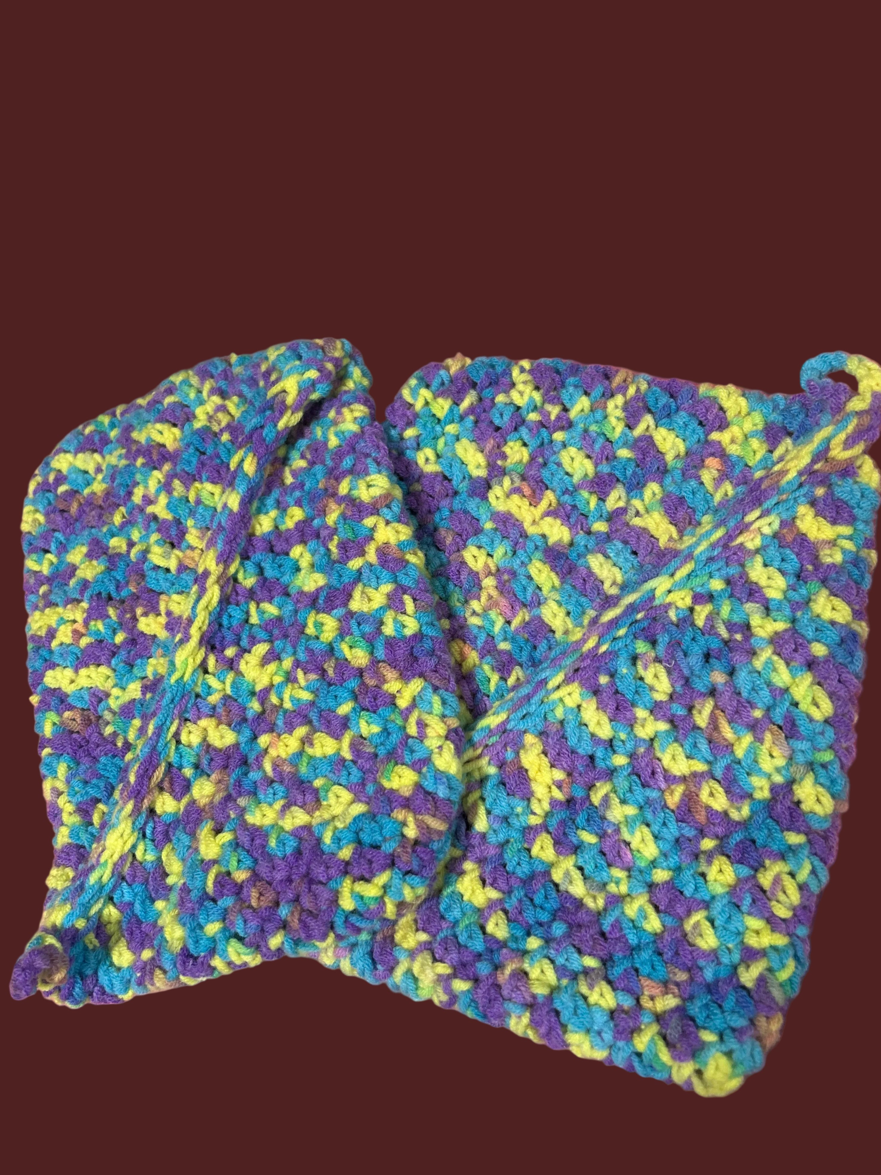 Colorful knitted scarf on a pink surface